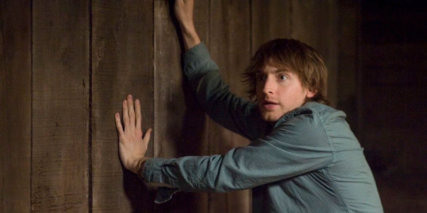 Marty holding onto the wall in The Cabin in the Woods