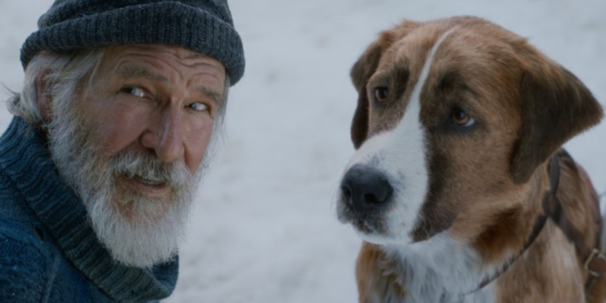 Harrison Ford sits with Buck in The Call of the Wild