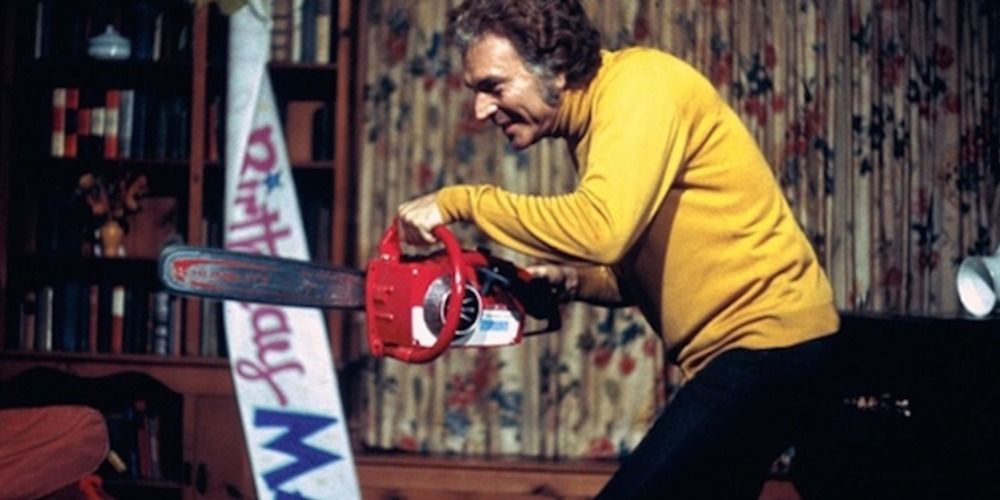 Dr. John Collingwood holding a bloody chainsaw in The Last House On The Left