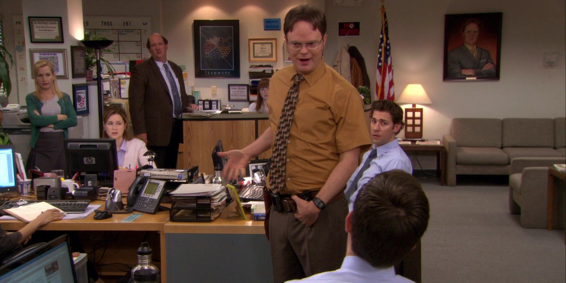 An image of Dwight standing in the office as the workers watch him