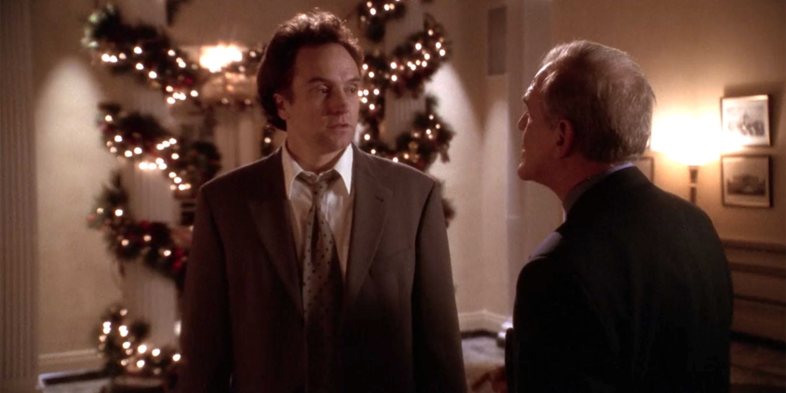A character standing in front of Christmas decorations in The West Wing