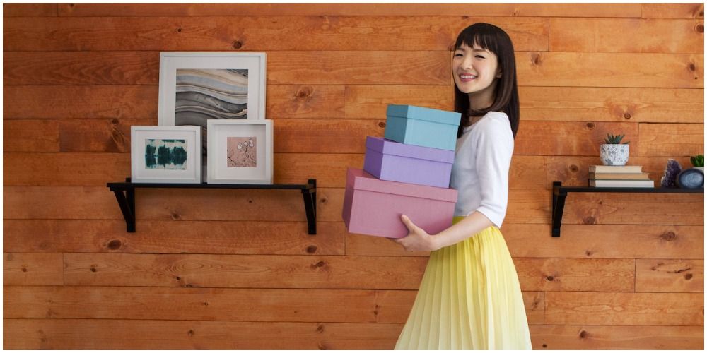Marie Kondo Walking And Smiling With Boxes In Her Arms