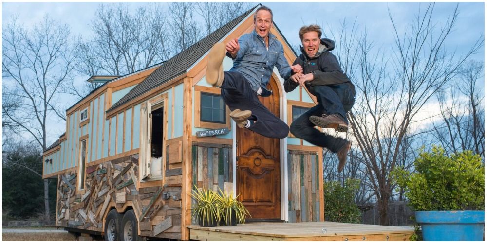 Hosts Jumping For Joy In Front Of Tiny House