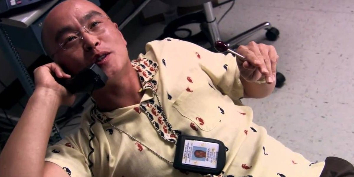 Vince Masuka leans back in his chair and talks on the phone in Dexter.