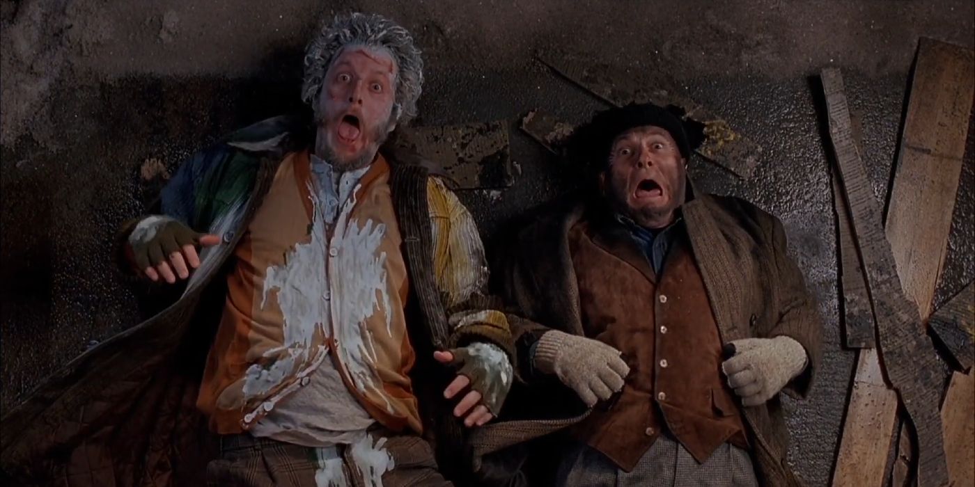 Harry e Marv deitados embaixo da casa gritando em Home Alone 2: Lost In New York (1991)