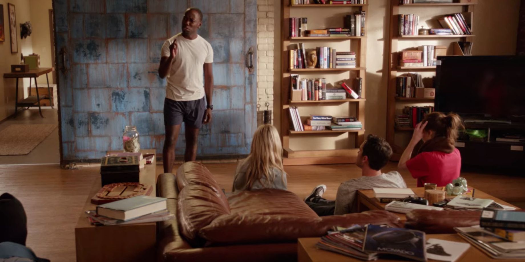 Winston gives his Theodore K. Mullins speech in front of his roommates and their guests in the living room in New Girl