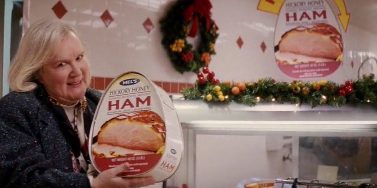 A woman holds up a Hickory Honey Ham in Christmas with the Kranks
