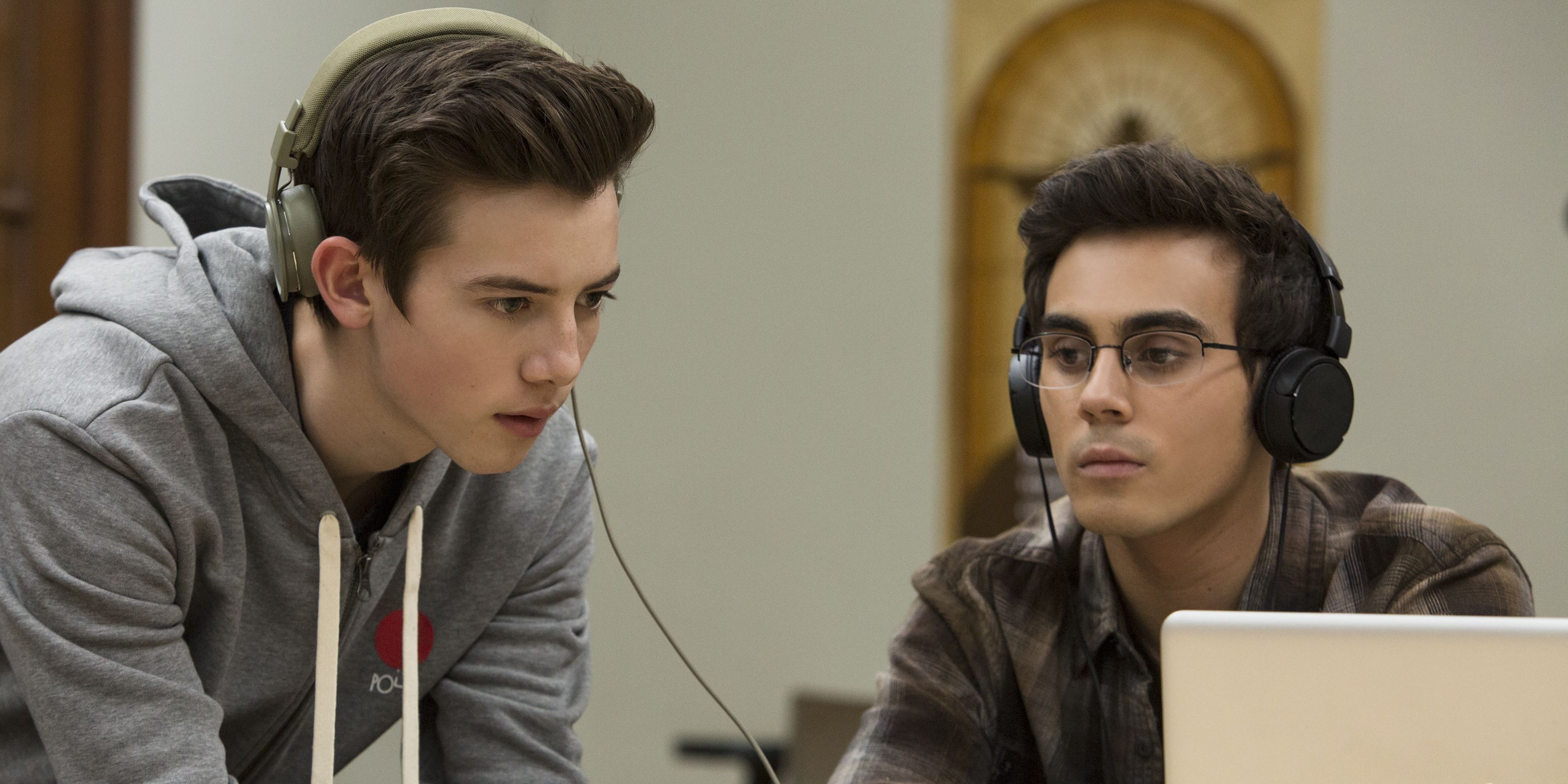 Sam and Peter from American Vandal wear headphones and look at something on a laptop
