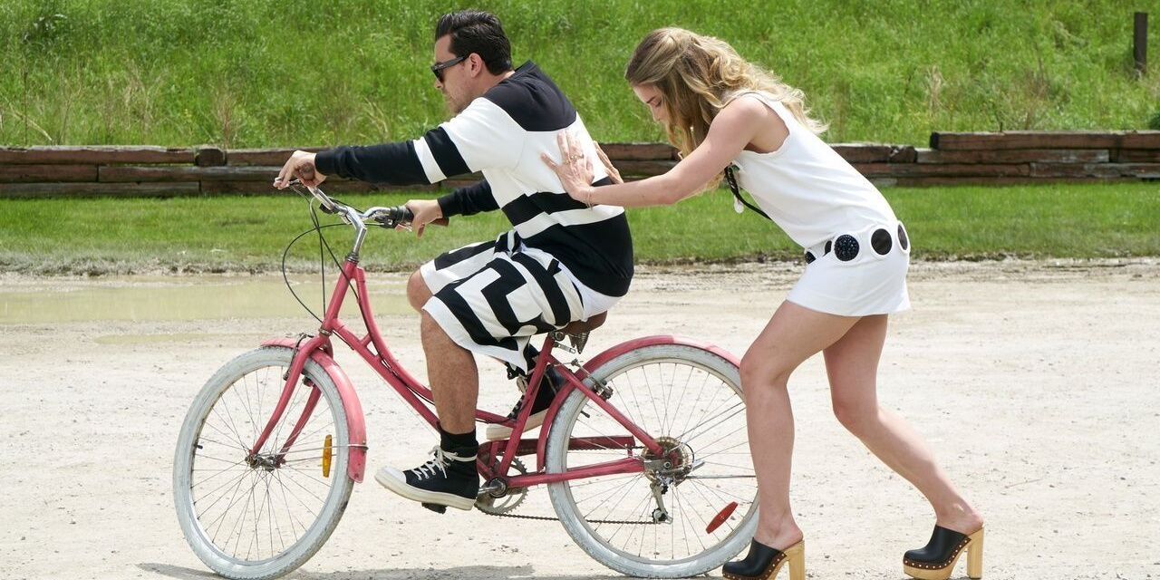 Alexis pushes David on a bike on Schitt's Creek