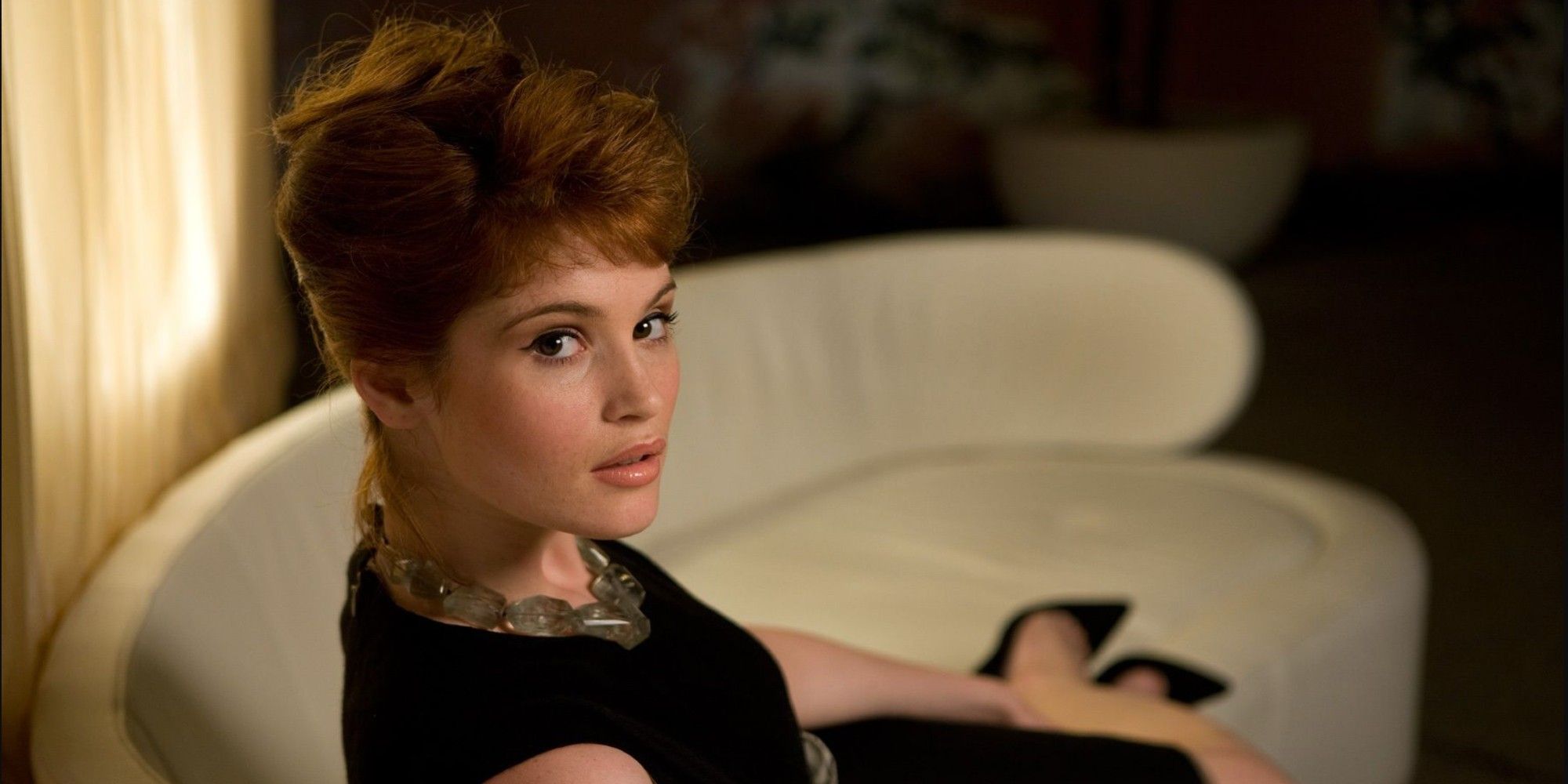 Gemma Arterton in a chair looking up in Quantum of Solace