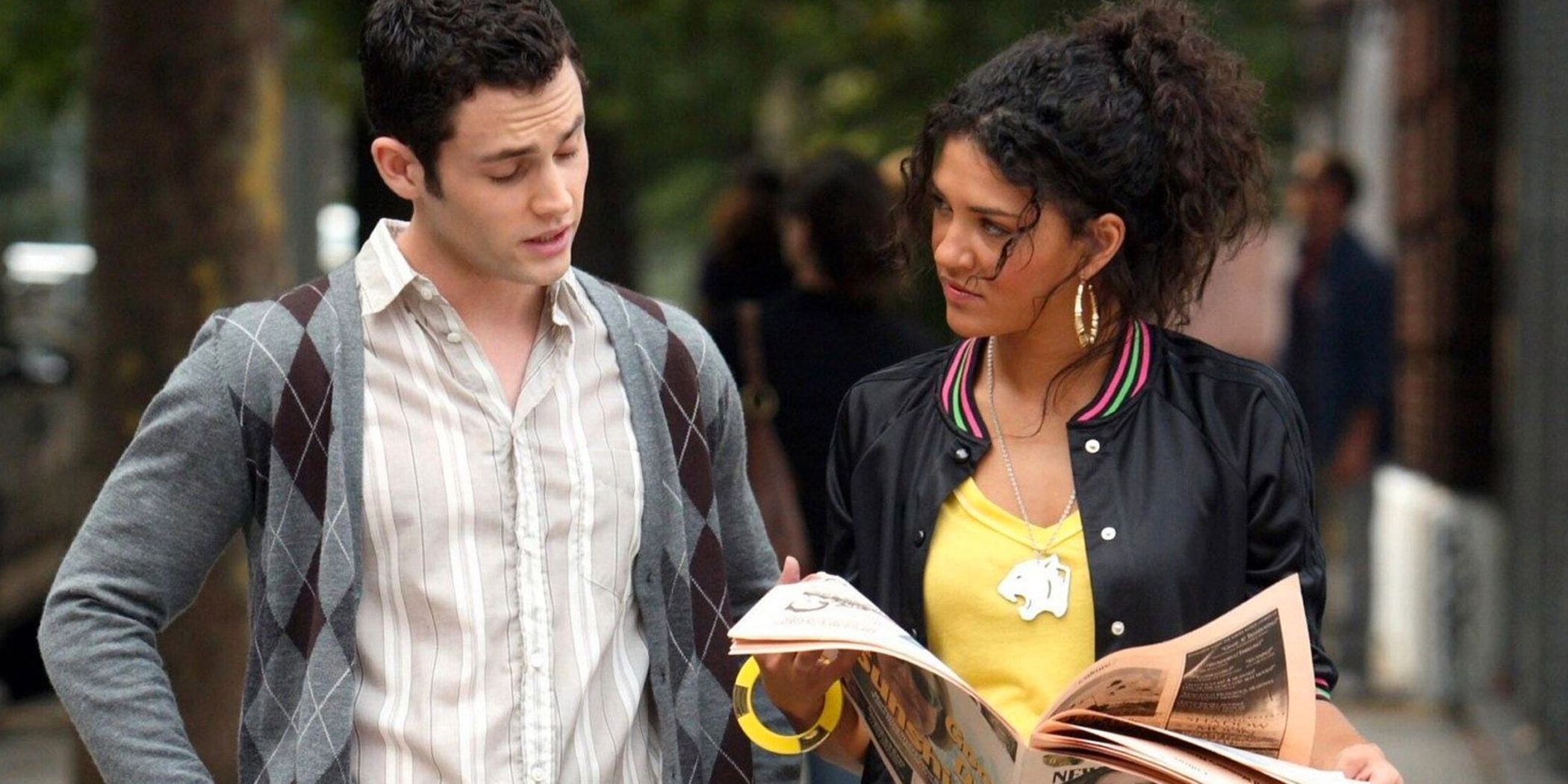 Vanessa and Dan walking together while Vanessa reads newspaper