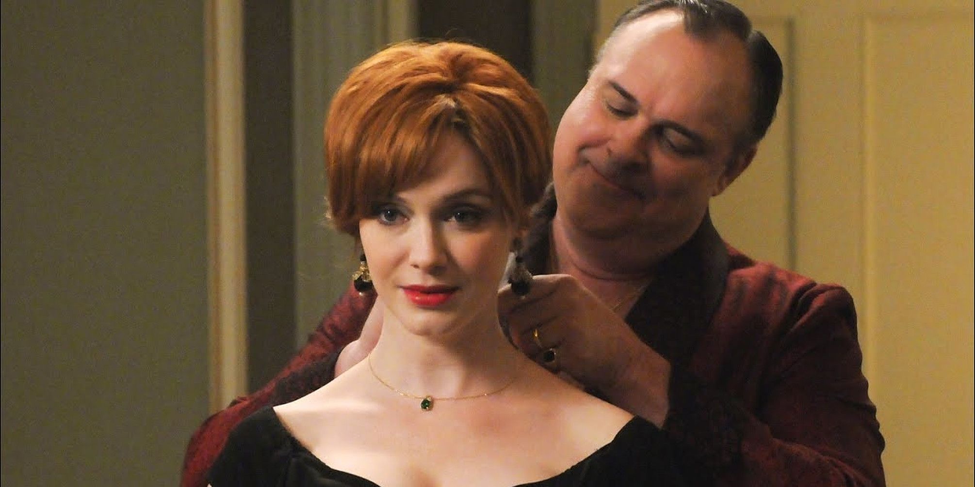 Herb putting a necklace on Joan in Mad Men
