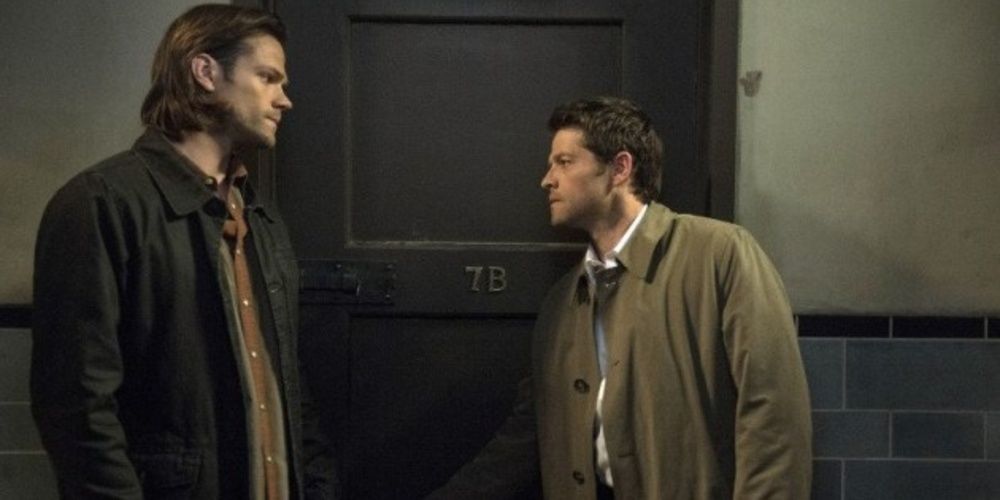 Sam and Castiel about to open a door in Supernatural