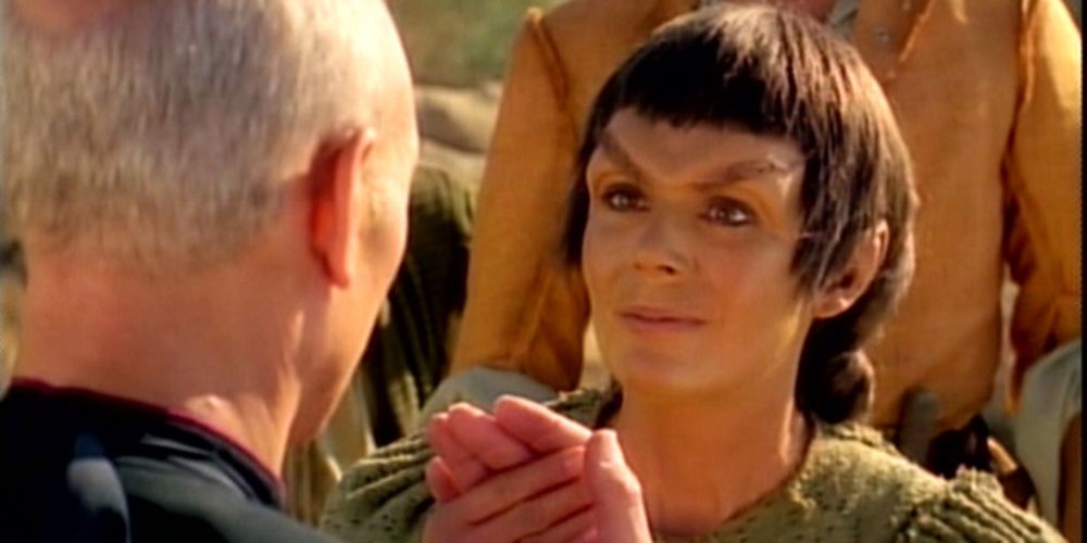 A Mintakan holds Picard's hand