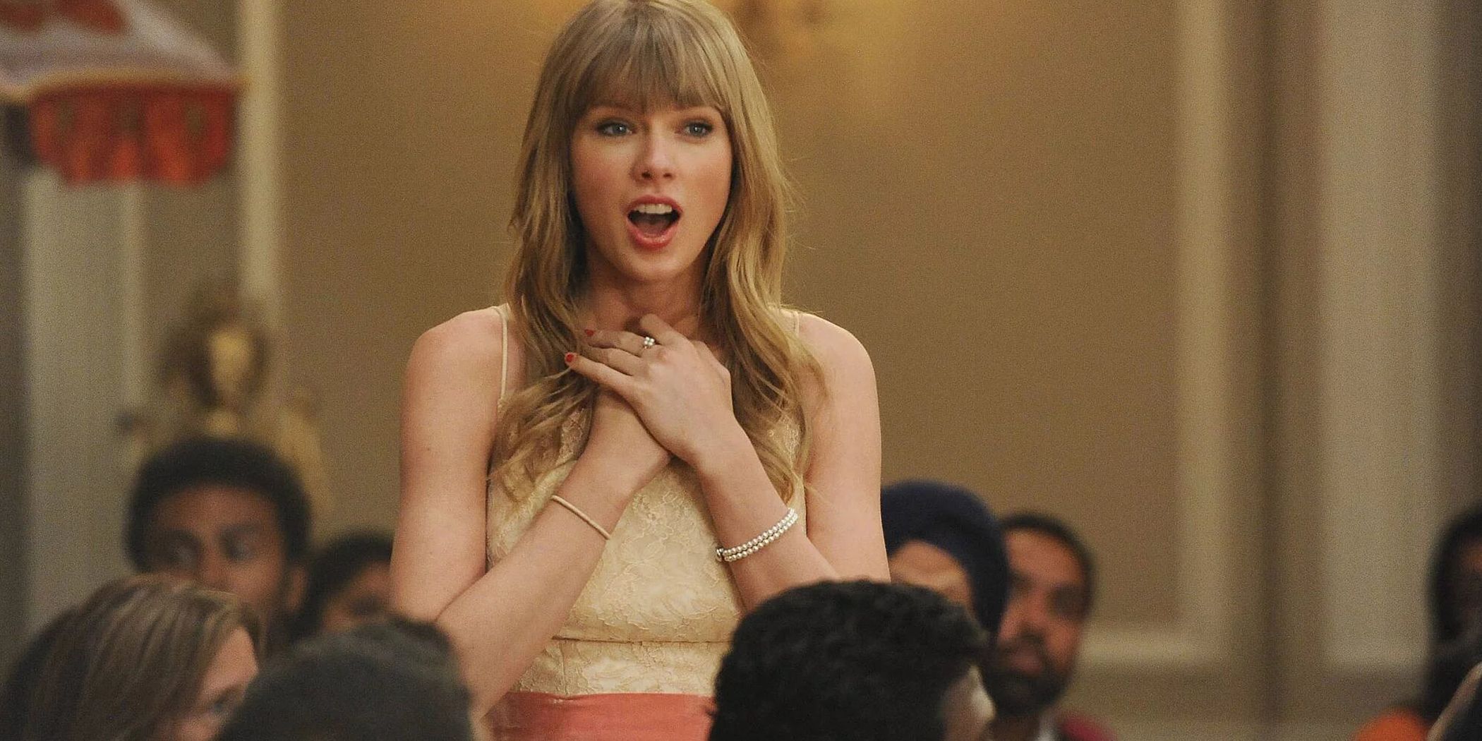 Taylor Swift as Elaine with her hands on her chest in New Girl