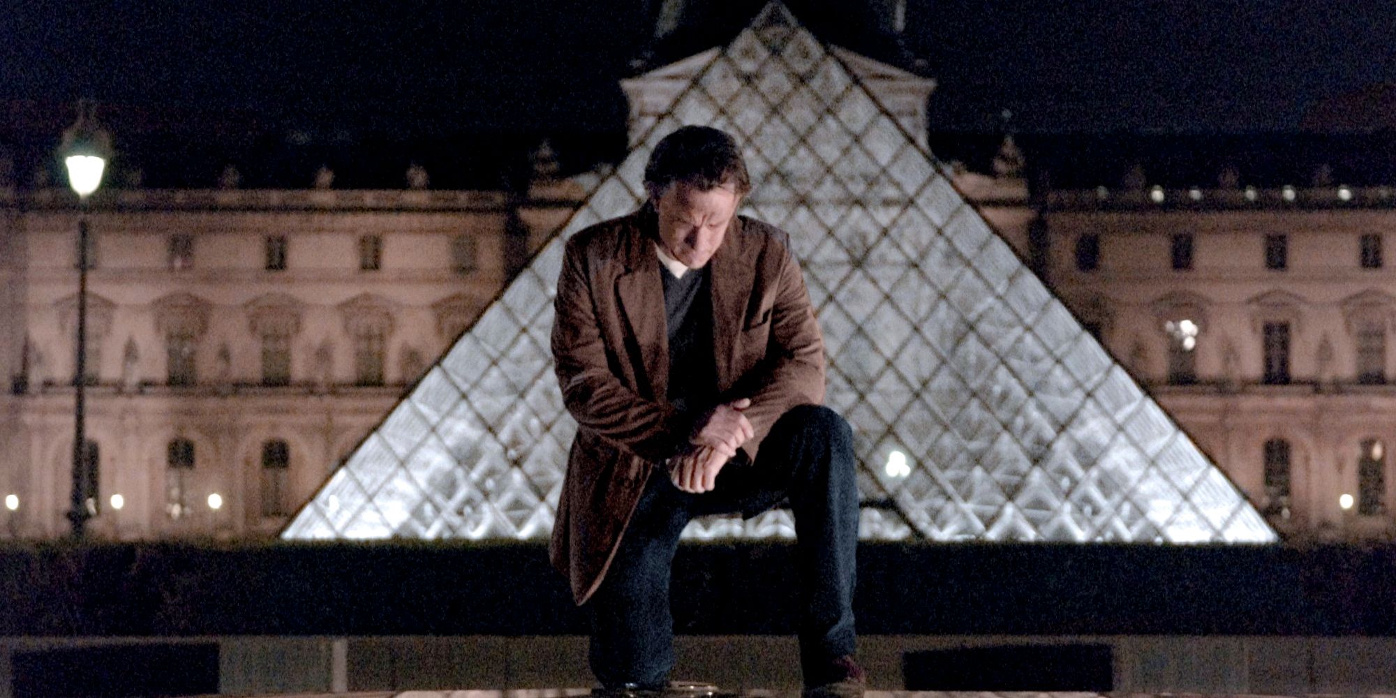 Langdon kneels in front of the Louvre in The Da Vinci Code
