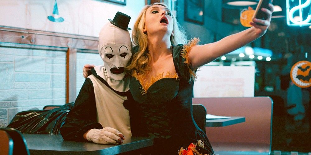 A woman takes a selfie with Art the Clown from Terrifier 
