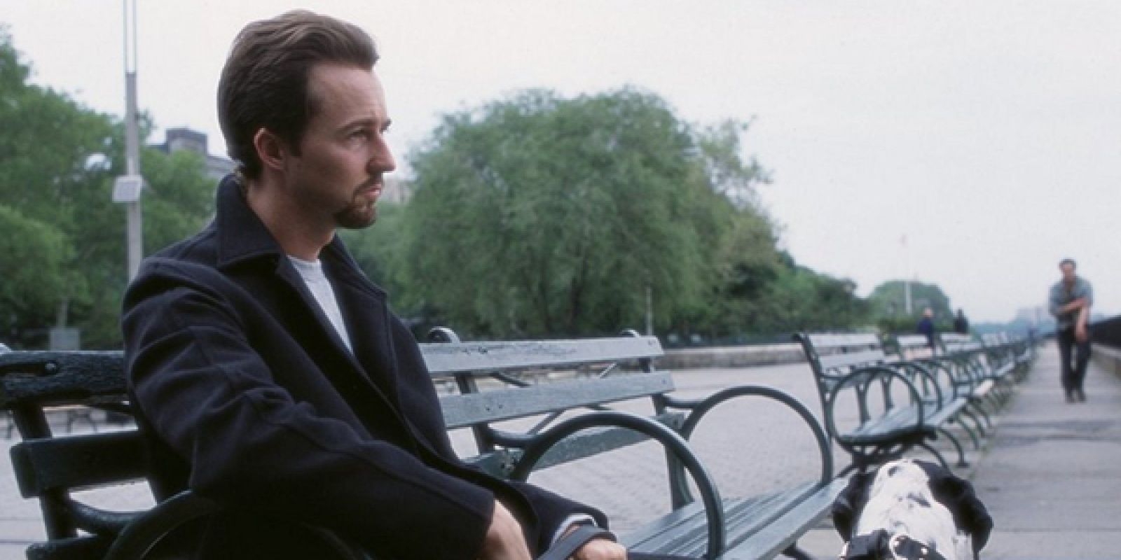 Edward Norton sits on a park bench outside in The 25th Hour.