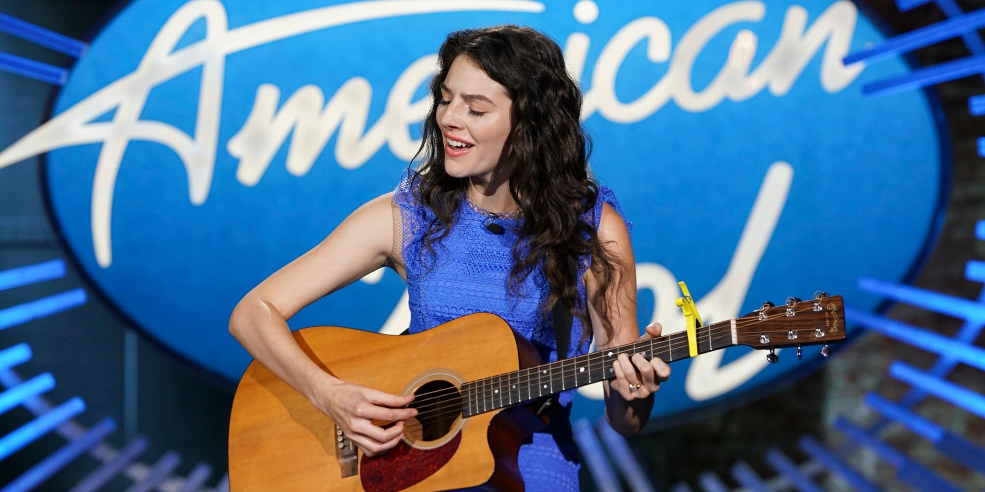 90 Day Fiance star Evelyn Cormier American Idol wearing blue playing a guitar