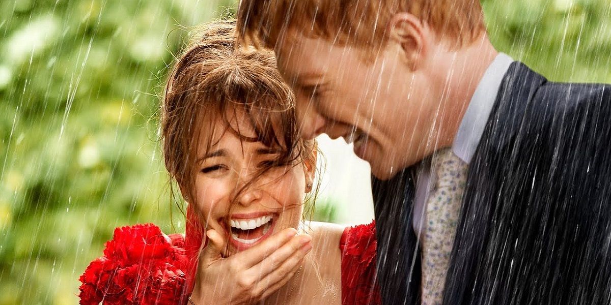 Domnhall Gleeson and Rachel McAdams laughing in the rain in About Time.