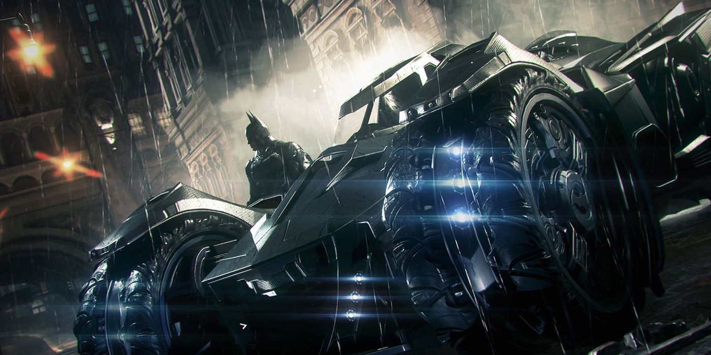 Promotional screenshot for Batman: Arkham Knight showing the Batmobile parked in a Gotham City street with the Dark Knight stood to the left of it.