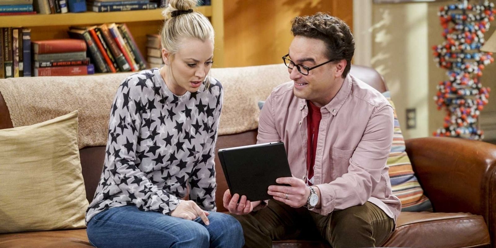 Penny and Leonard sitting on couch looking at tablet