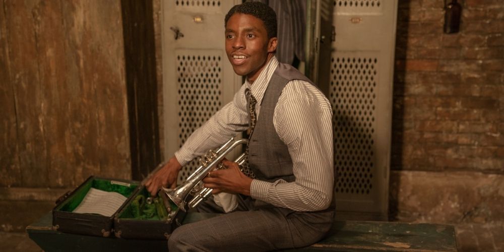 Levee sitting and smiling while holding his trumpet