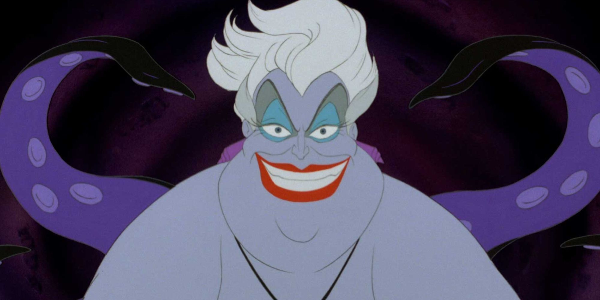 Ursula smiling with her tentacles moving behind her in The Little Mermaid