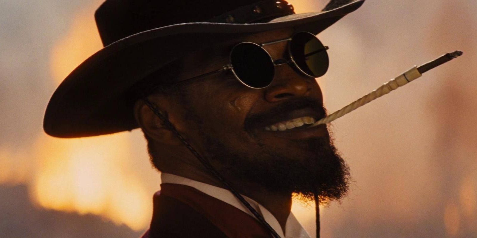 Jamie Foxx sorrindo com cigarro e óculos escuros no final de Django desencadeado