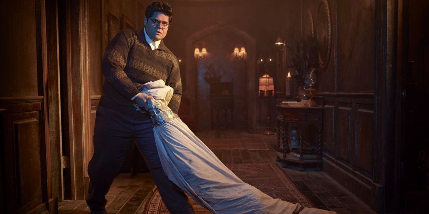 Guillermo dragging a corpse in the hallway in What We Do In The Shadows.