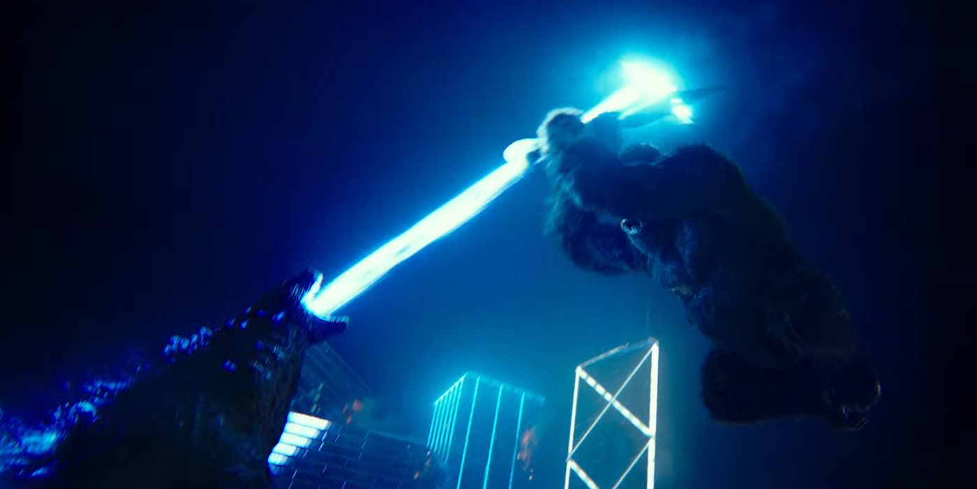 Godzilla's atomic breath shooting at Kong holding a battle axe