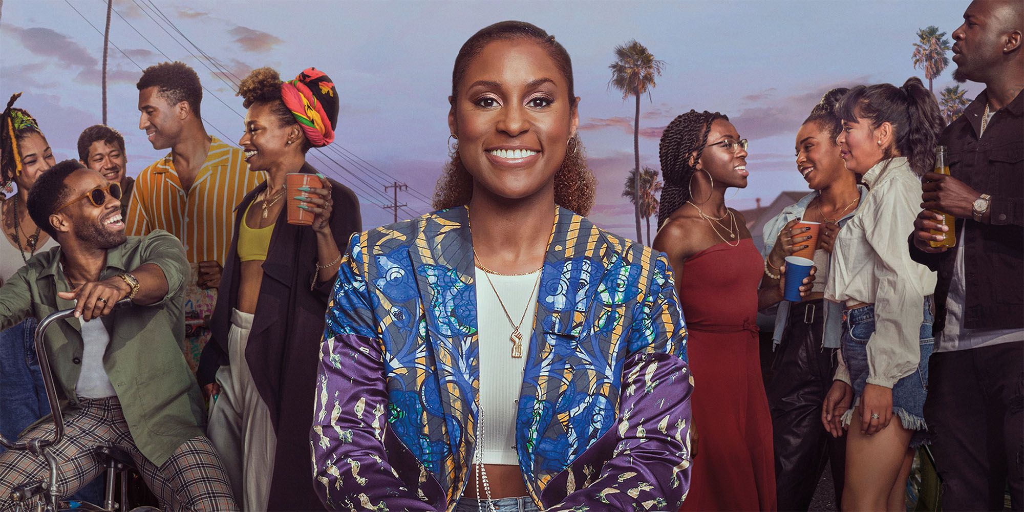 Image of Issa Rae and the rest of the cast of Insecure outside holding drinks with palm trees in the background.
