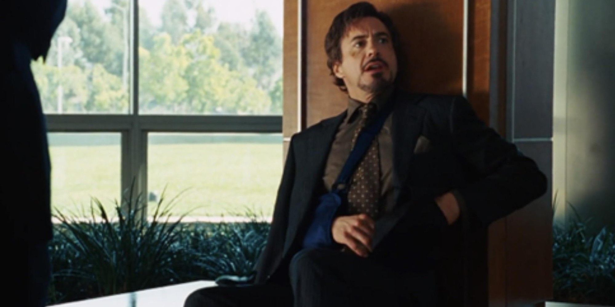 Tony eats a cheeseburger at a press conference in Iron Man