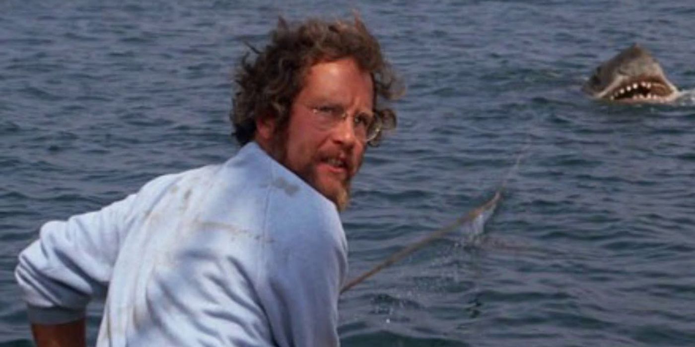 Richard Dreyfuss as Matt Hooper on the boat with the shark in the near distance in Jaws