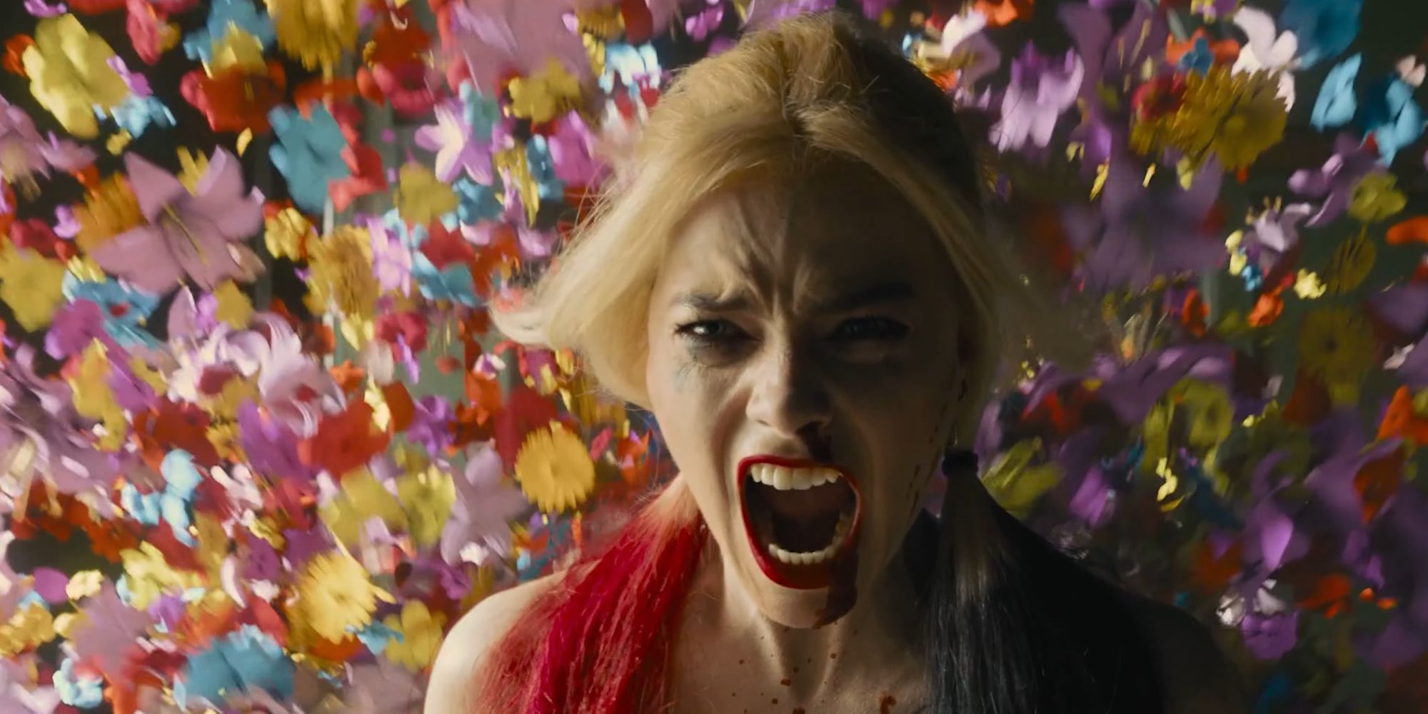 Margot Robbie's Harley Quinn letting out a battle cry as flowers shower in The Suicide Squad