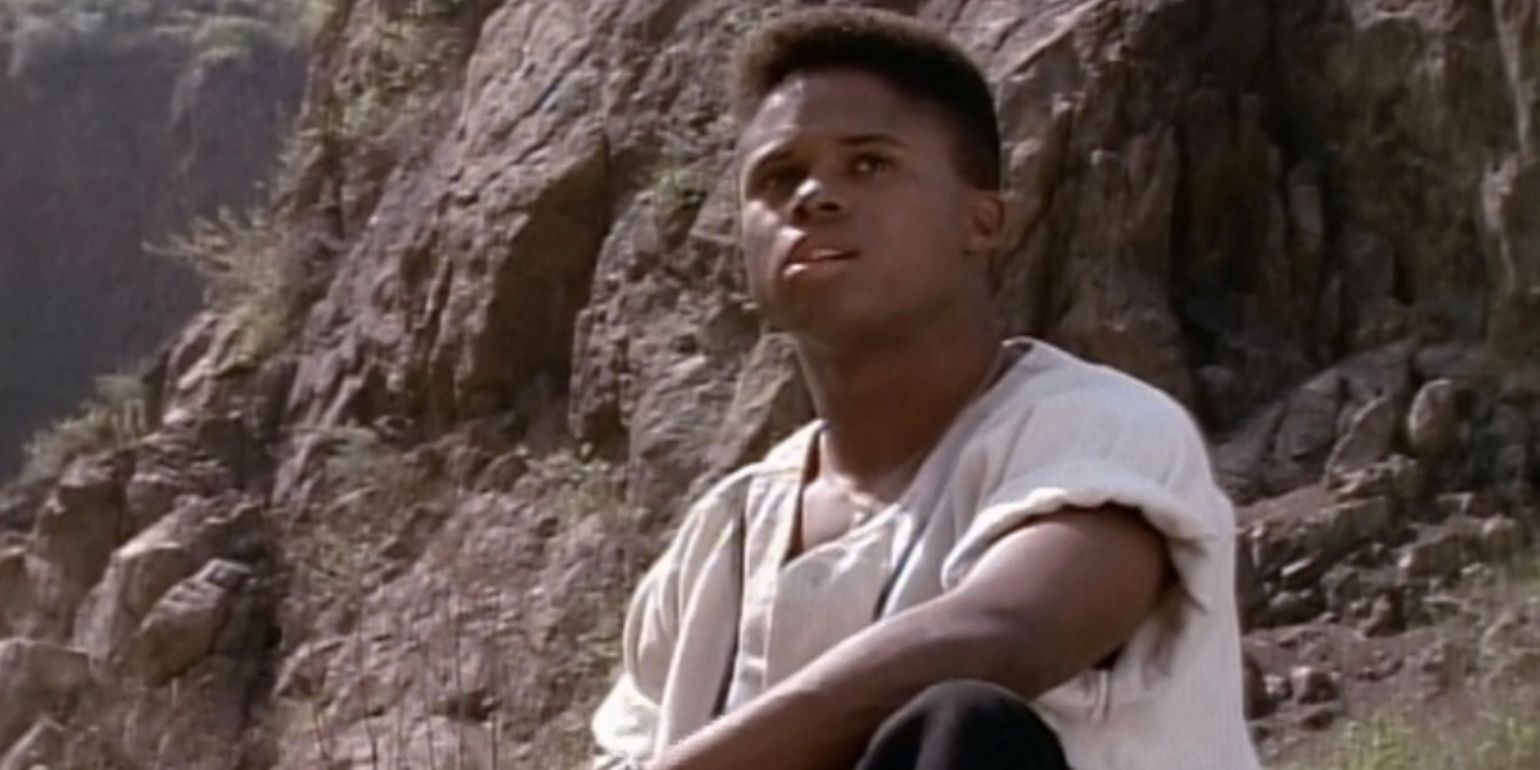 Zack sits on the rocks outside of the command center in Mighty Morphin Power Rangers