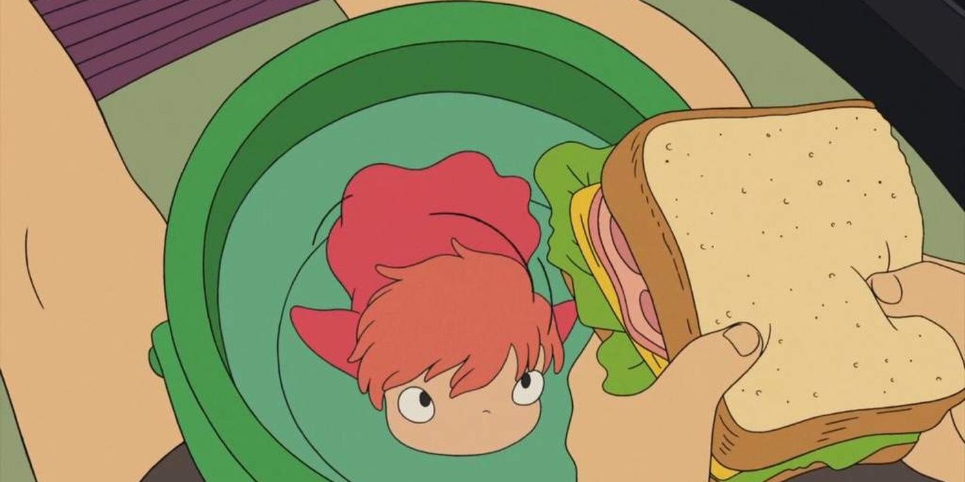 Ponyo in goldfish form swims in a bucket and looks up at a ham sandwich in Ponyo