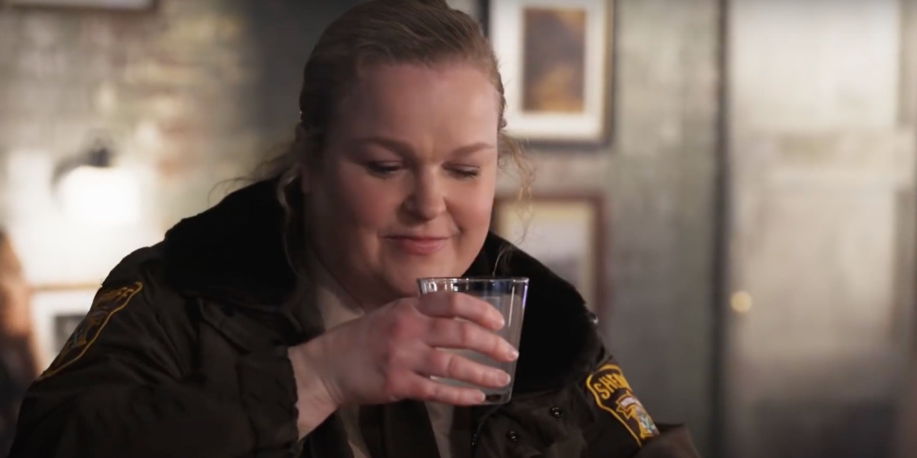 Elizabeth Bowen as Deputy Liv enjoys a drink in Resident Alien on SyFy