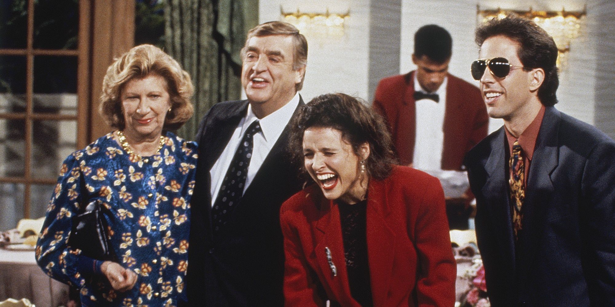 Elaine laughs while on pain meds while standing with Jerry and his parents in Seinfeld