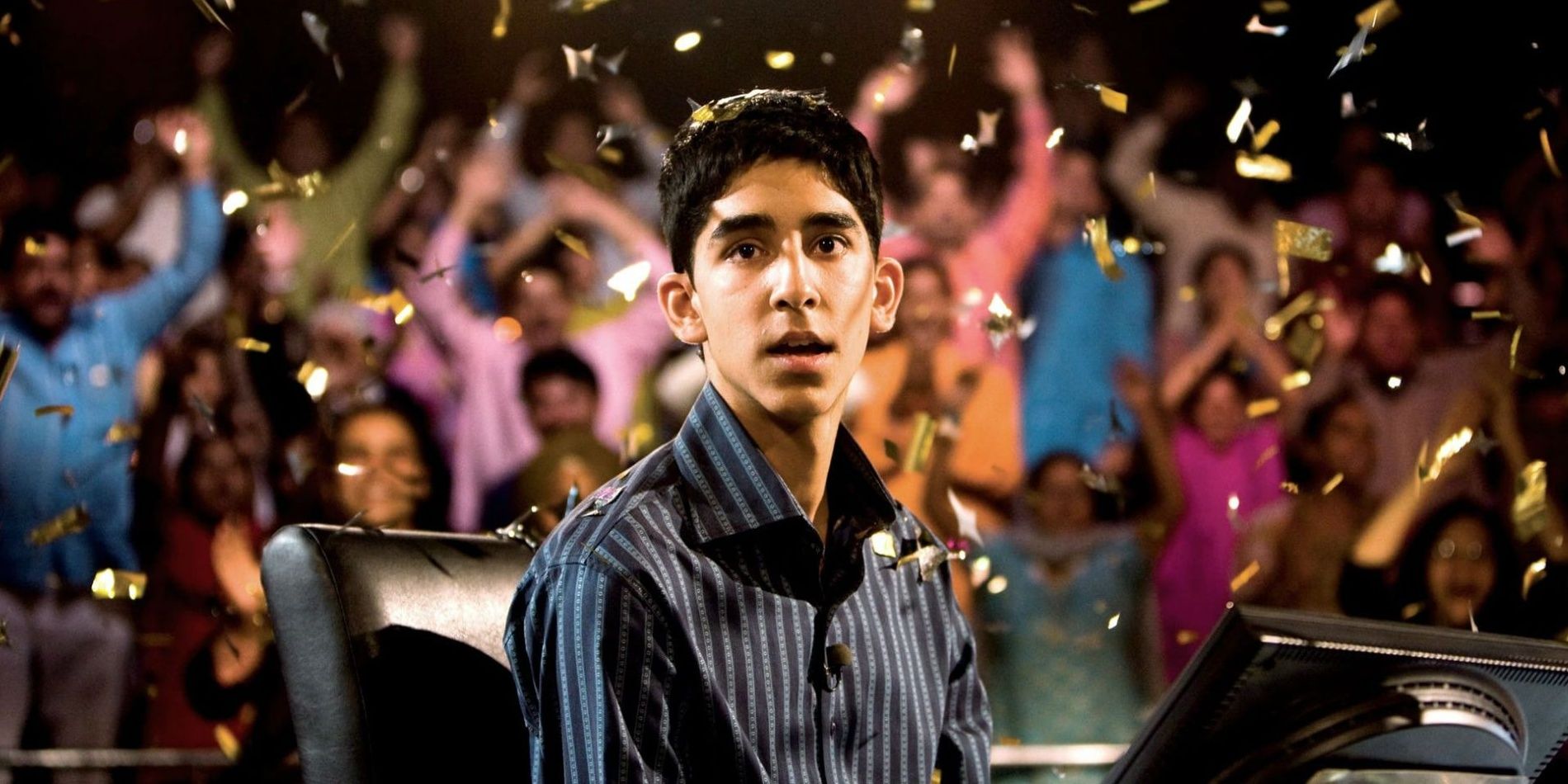 A man sitting in confetti in Slumdog Millionaire