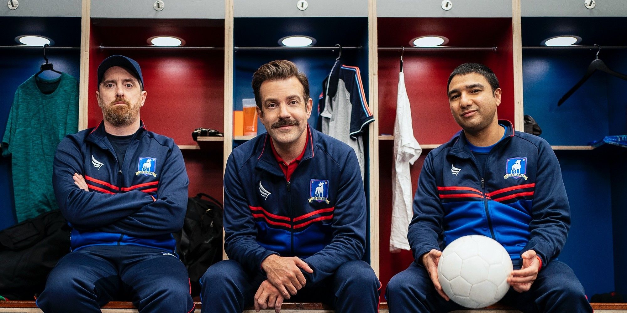 Ted Lassosits in a locker room with two other males in Ted Lasso.