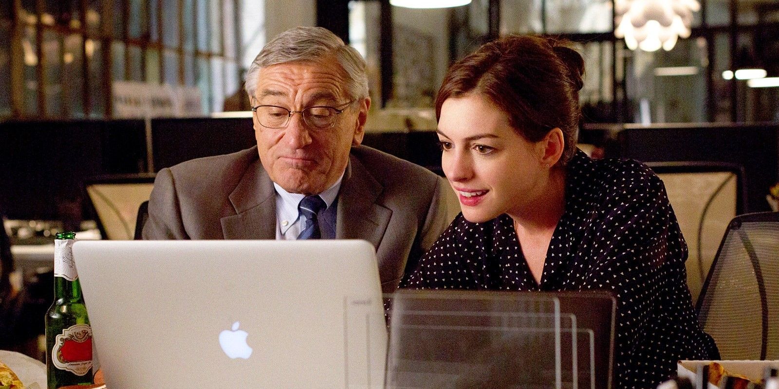 Anne Hathaway and Robert De Niro use a computer in The Intern 