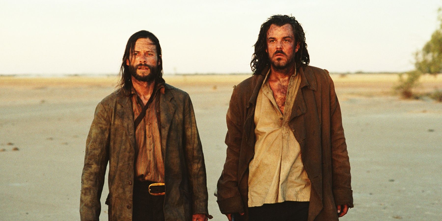 Guy Pearce and Ray Winstone walking somewhere in The Proposition