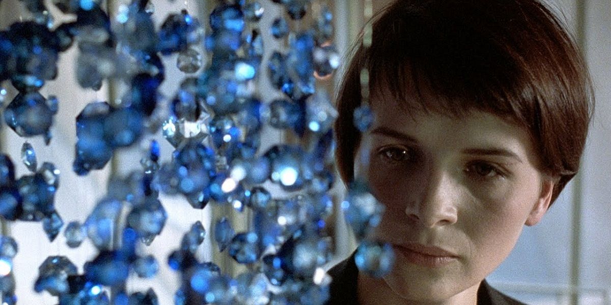 Juliette Binoche staring at a blue chandelier in a still from Three Colors: Blue