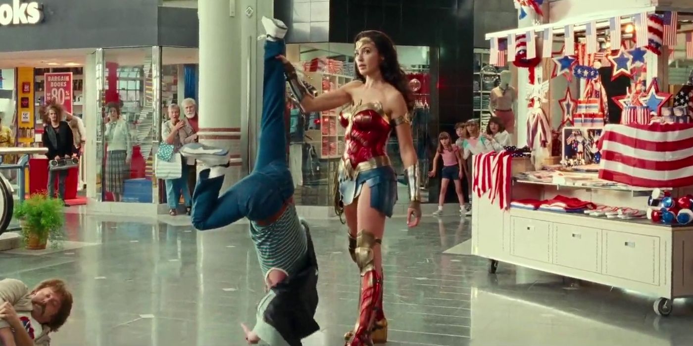 Wonder Woman holding a man by the ankle in Wonder Woman 1984