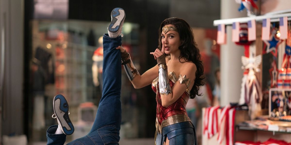 Wonder Woman holding a thief by the ankle and shushing