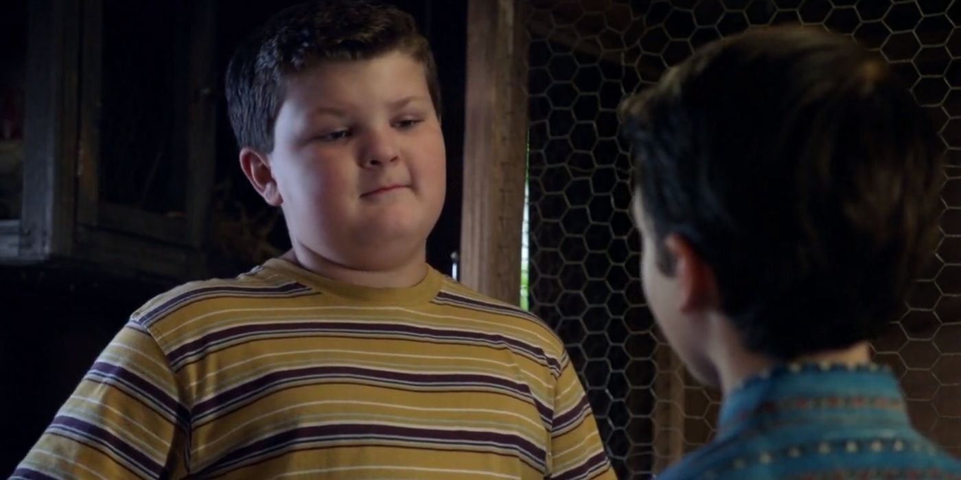 Billy Sparks from Young Sheldon wearing a striped shirt, looking at Sheldon.