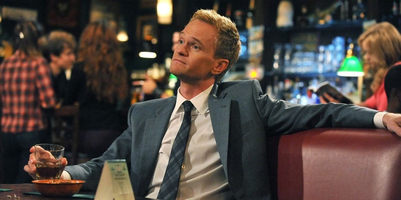 Barney sitting at the booth in How I Met Your Mother.