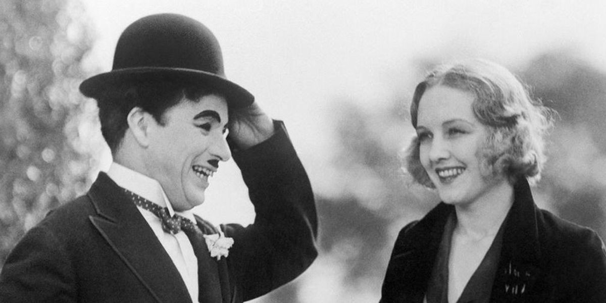 Charlie Chaplin laughing with a woman in City Lights.