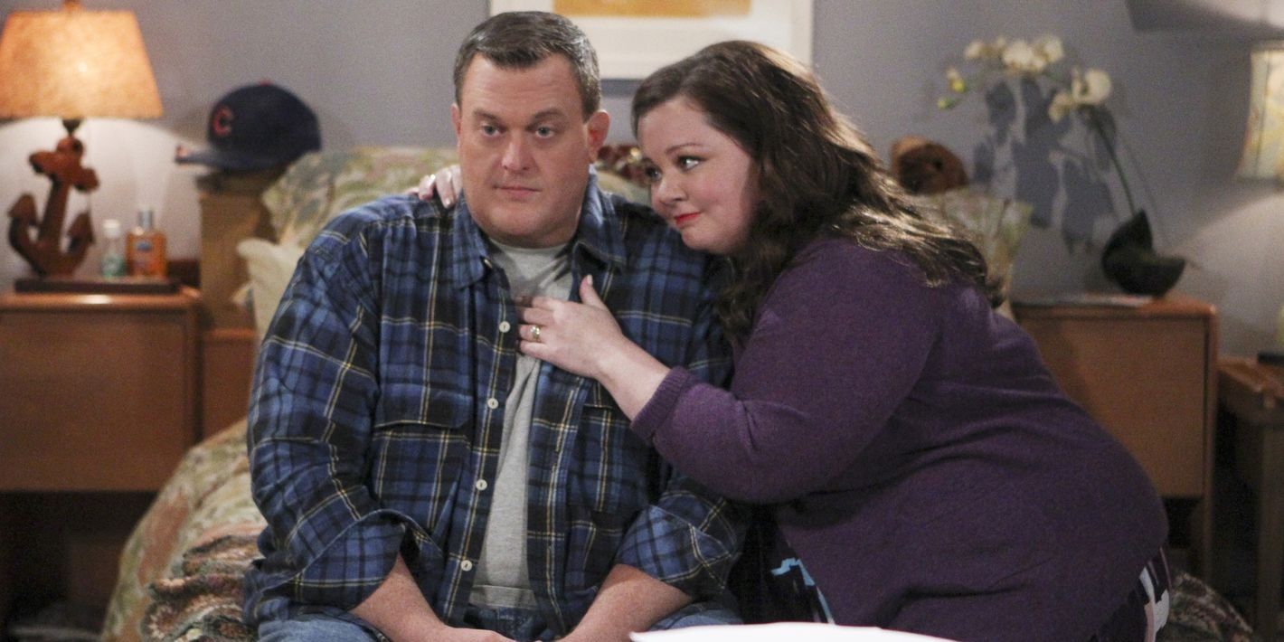 mike and molly hugging together at the edge of the bed.